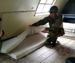 Un soldado muestra a la prensa el par de colchones donde el niño habría dormido dentro de la cabaña donde fue localizado este viernes