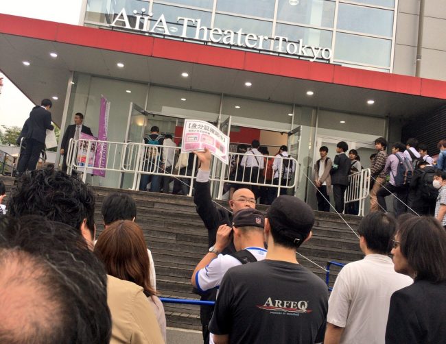 Personal de Nogizaka46 dando la informacion del nuevo requisito de ingreso al auditorio.